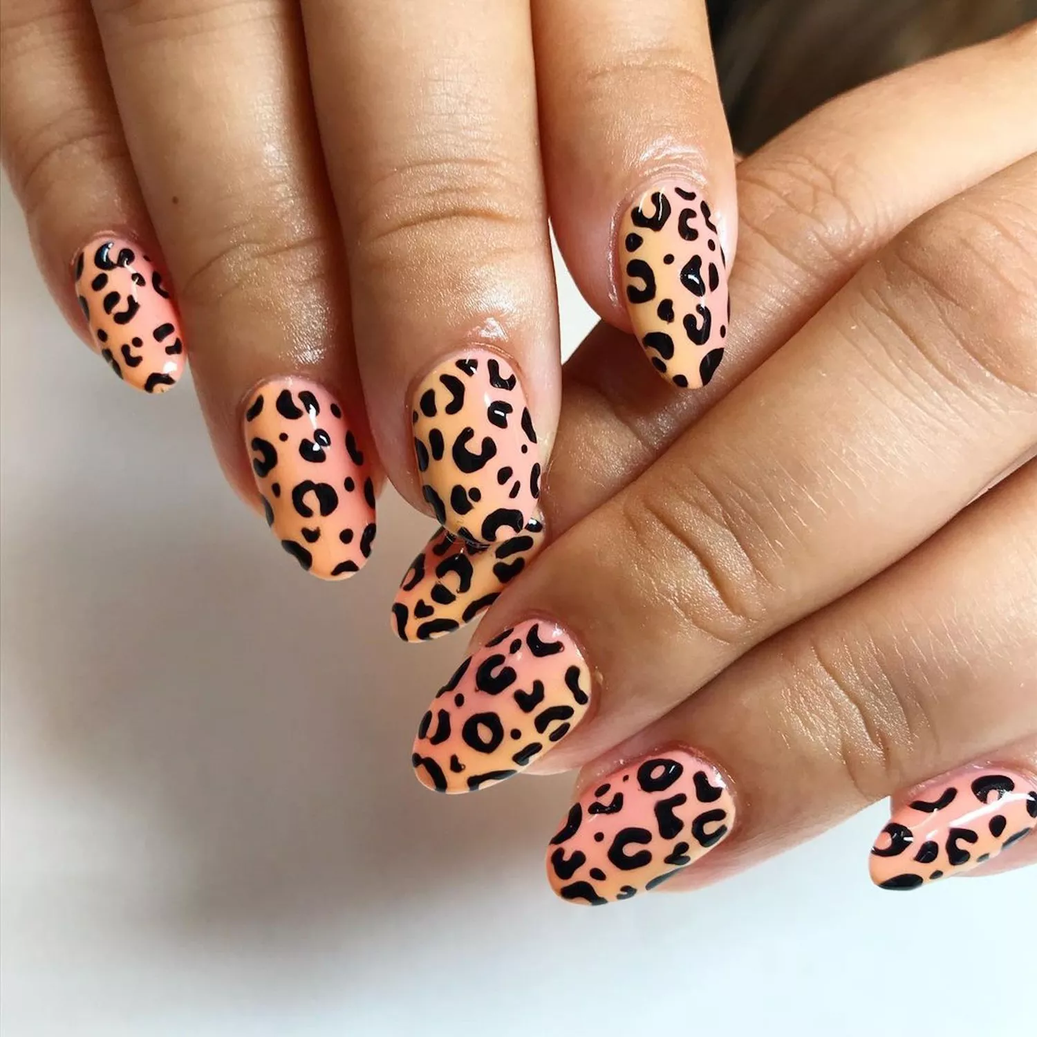 Peach nails with cheetah print designs