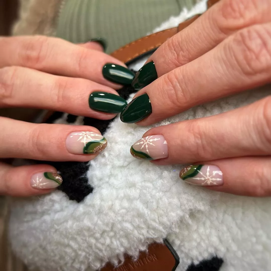 55+ Winter Nail Design Ideas 2025 9 A dark green manicure with swirls and snowflakes for winter.