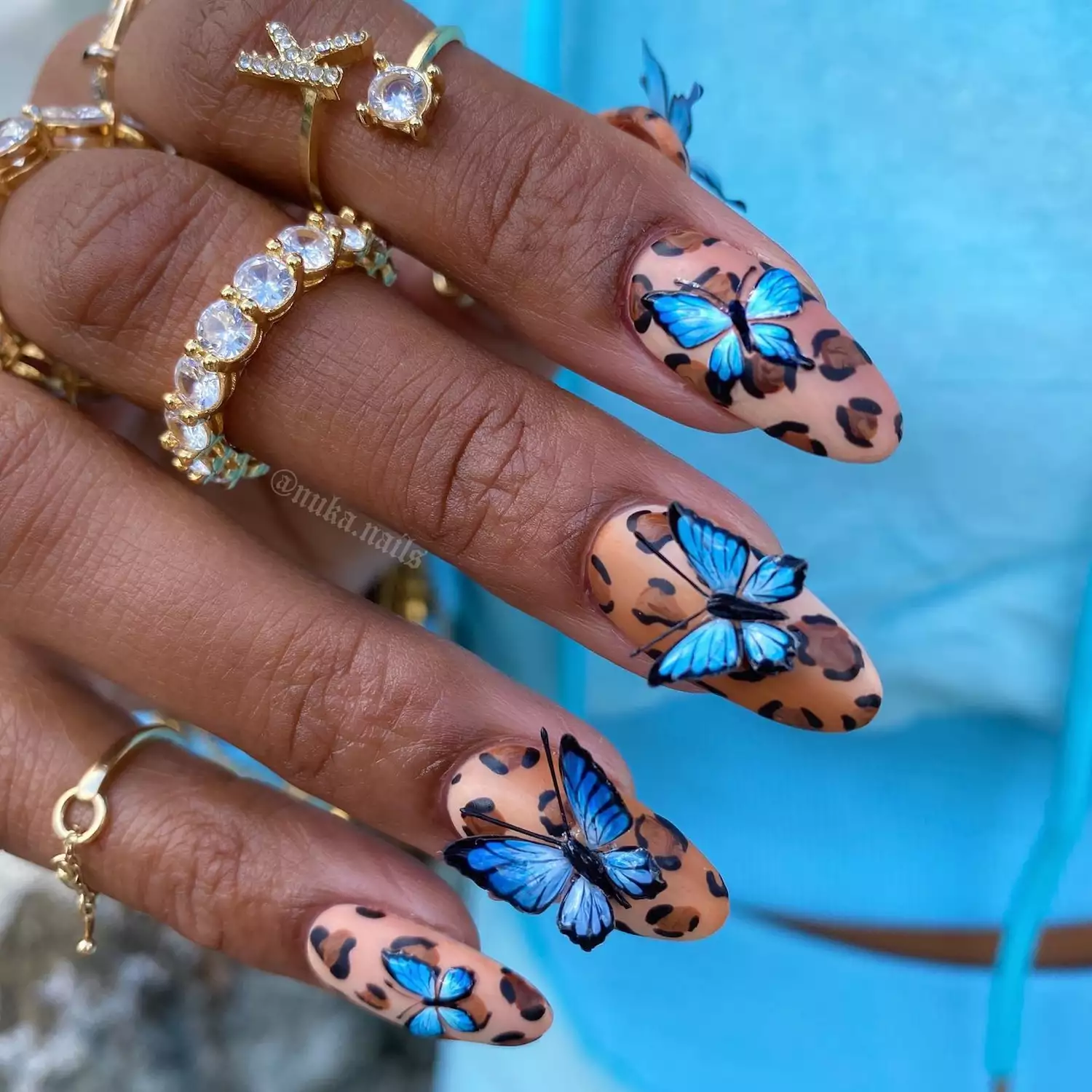 Leopard print manicure with butterfly accents