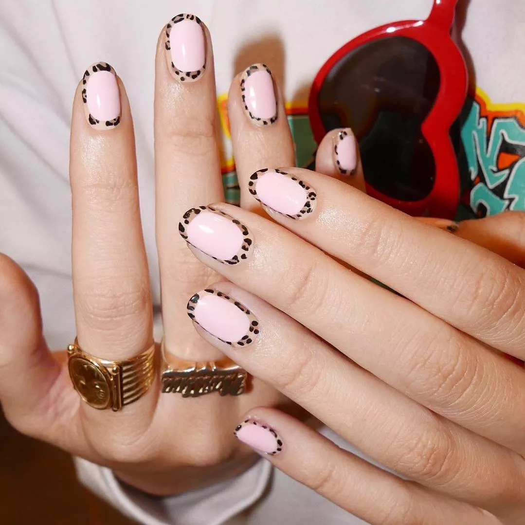 Baby pink manicure with a cheetah print outline