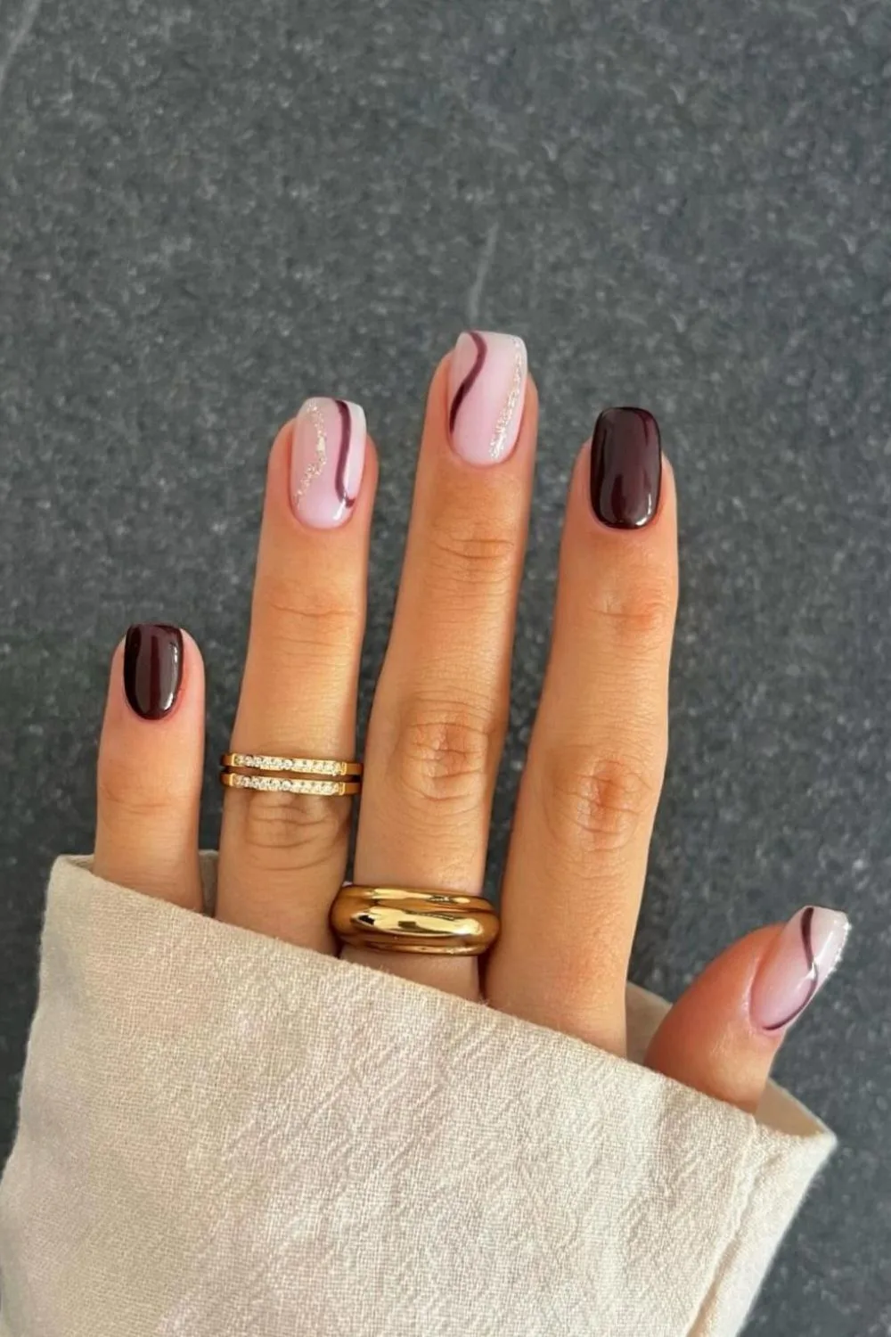 Deep brown nails with swirl accents