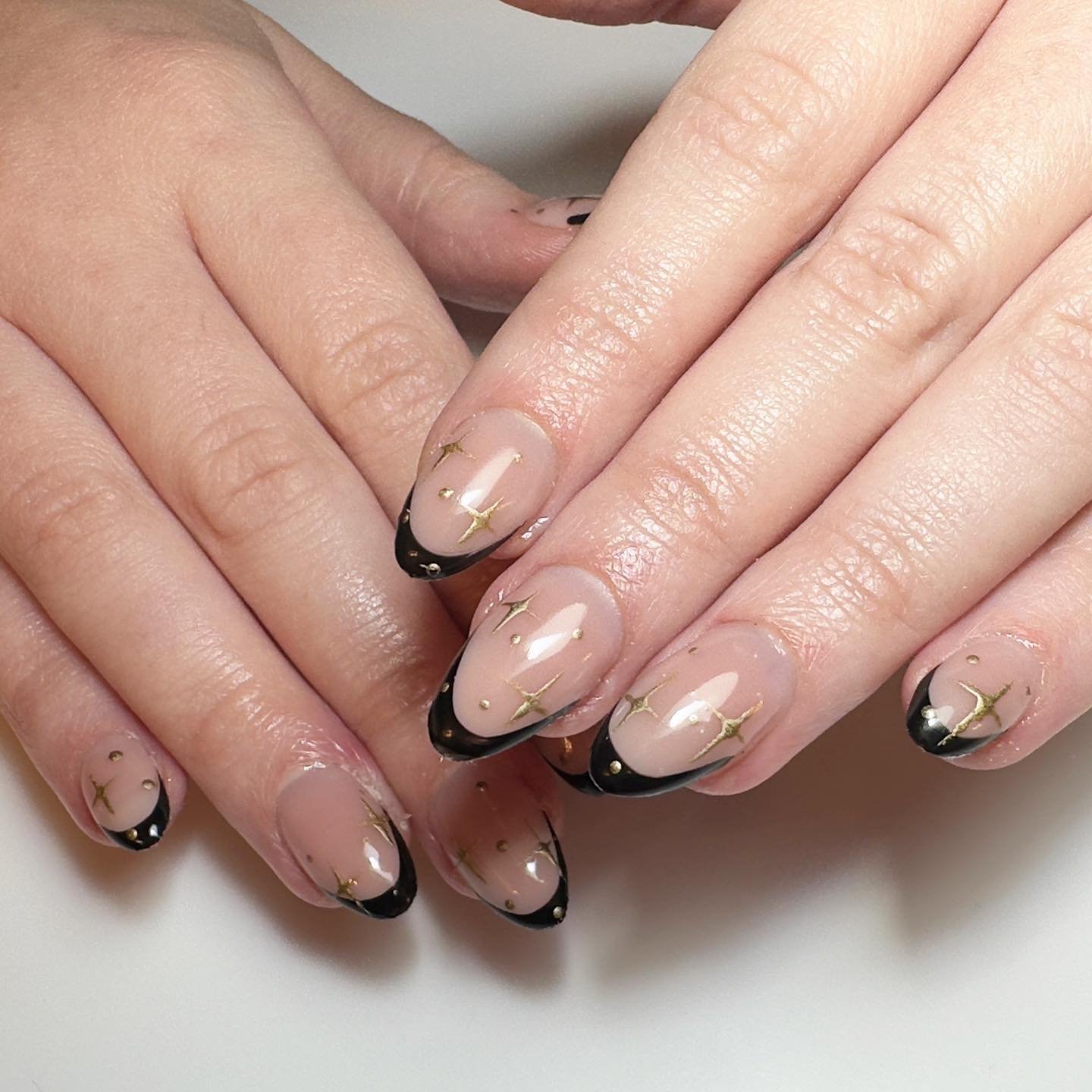 Black French manicure with gold stars