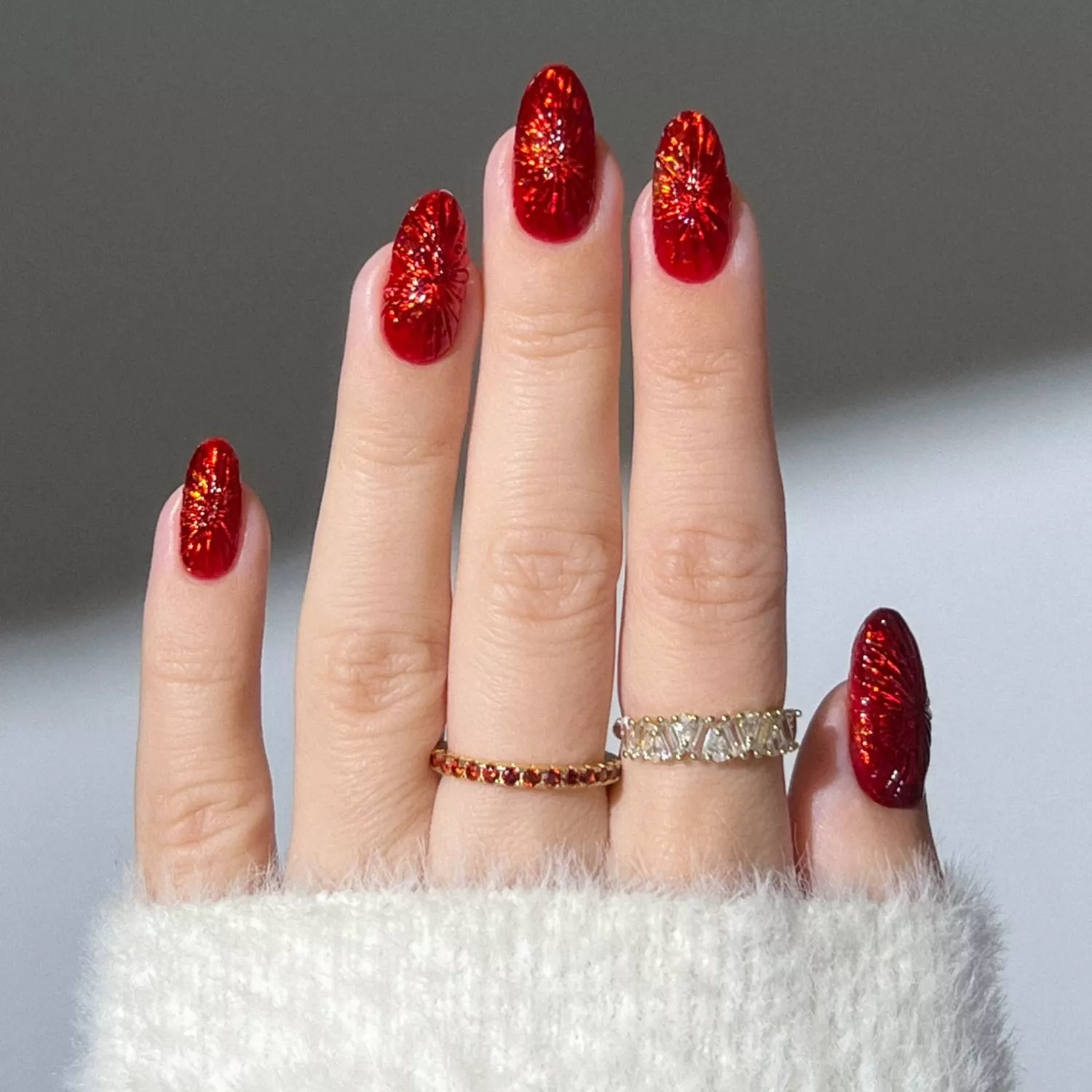 Close up of cranberry-red kaleidoscope nails.