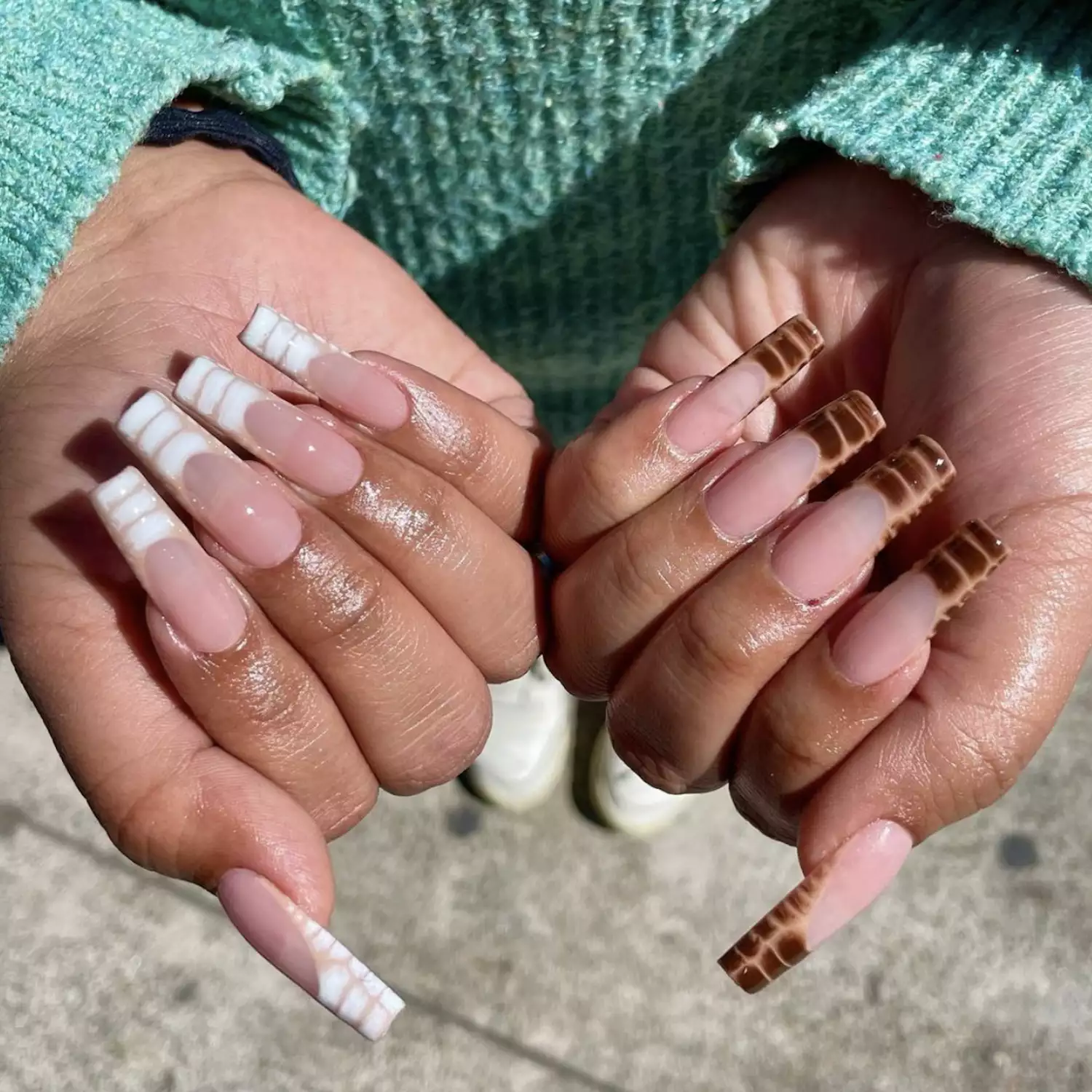 Long nails with nude base and white or brown snakeskin tips