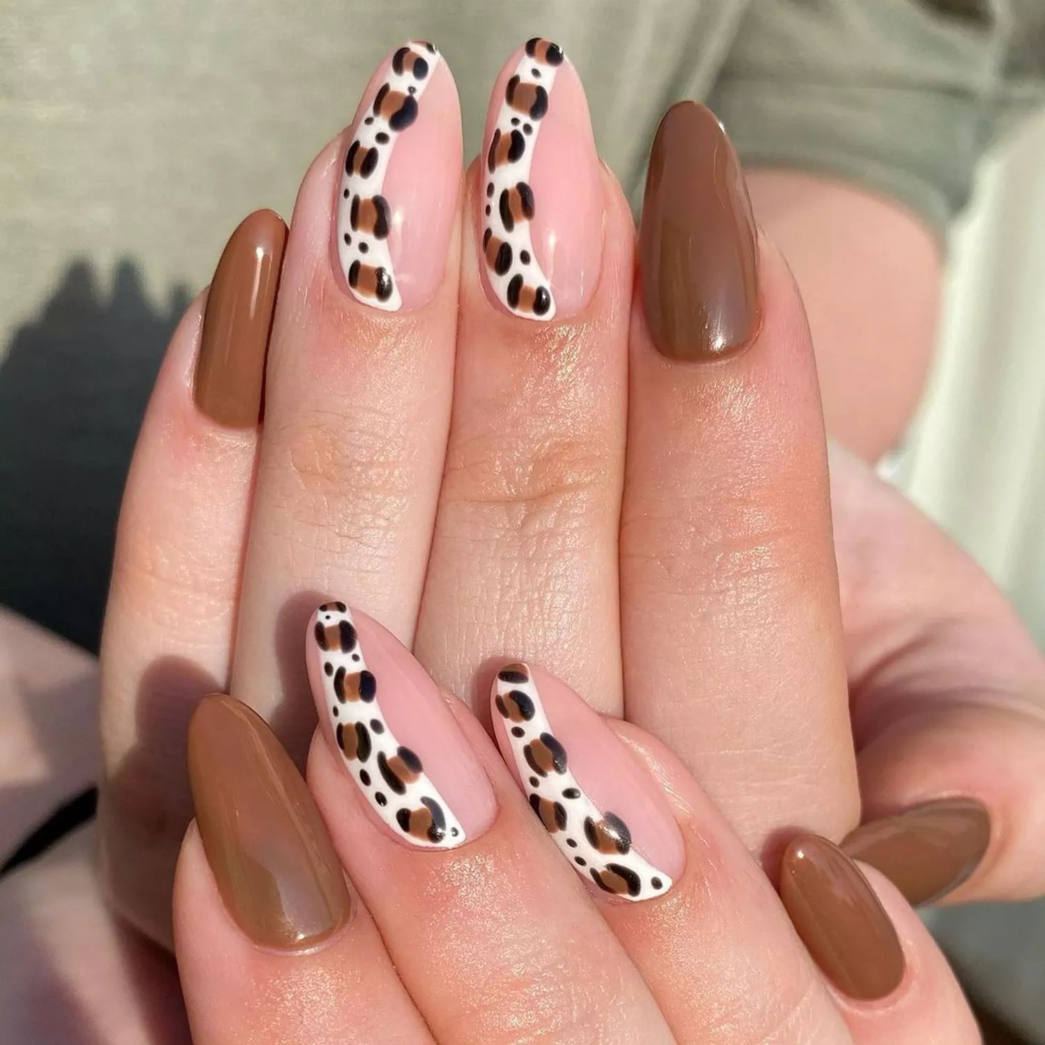 Close up of a brown manicure with leopard-print striped accent nails