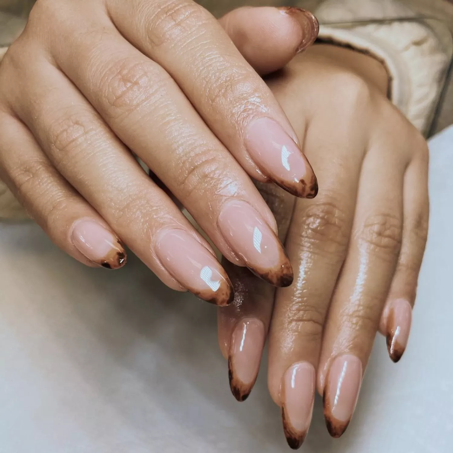 Almond-shaped nails with nude base and tortoiseshell tips