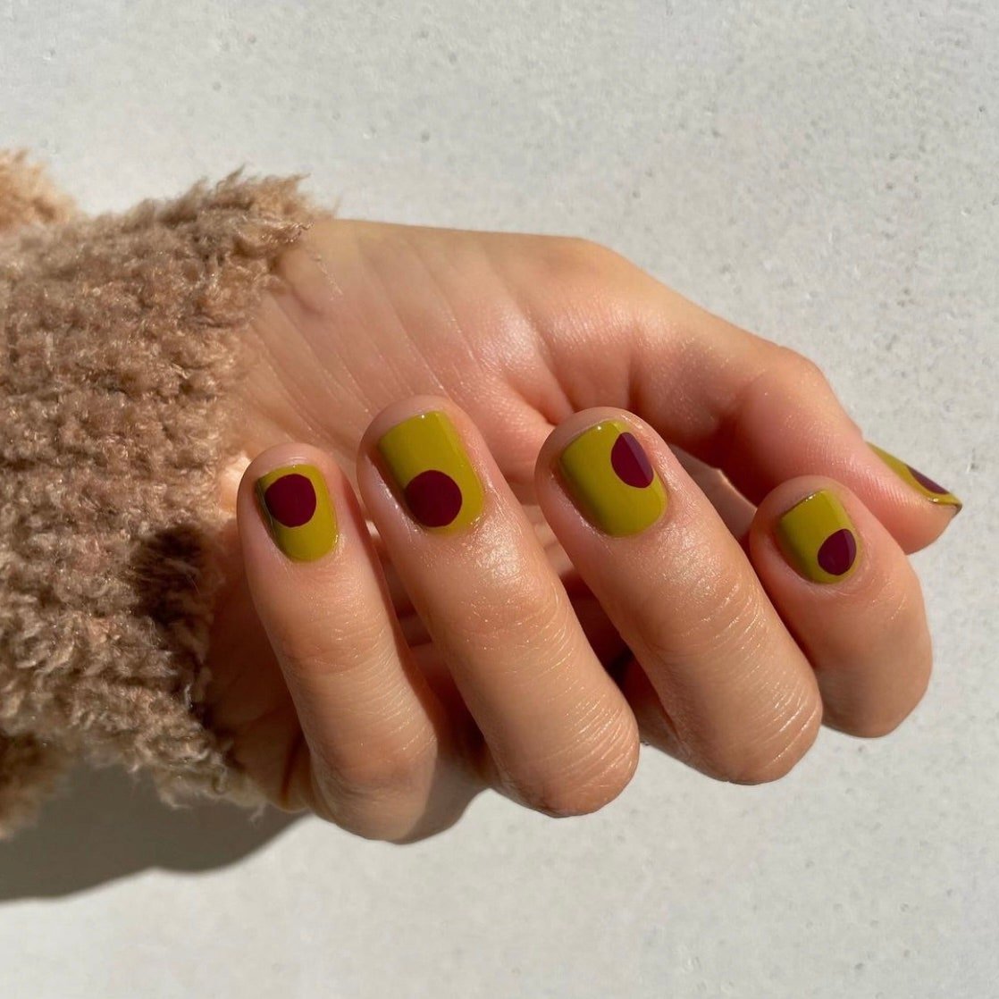 Olive green manicure with dark red dots